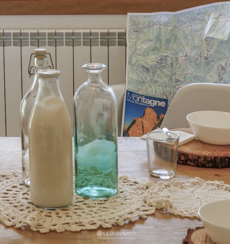 dettaglio tavolo in legno apparecchiato con rondelle di legno come sottopiatto, allestimento a Camporosso Tarvisio per appartamento in vendita 